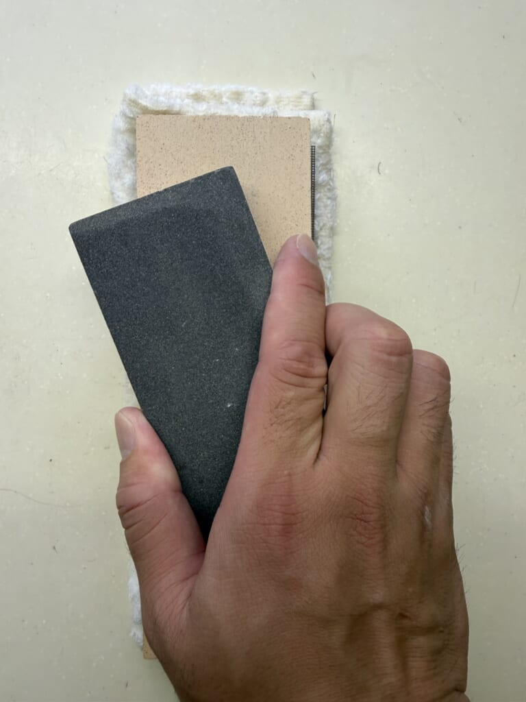 面直し砥石を使って砥石の表面を平らに整えている様子